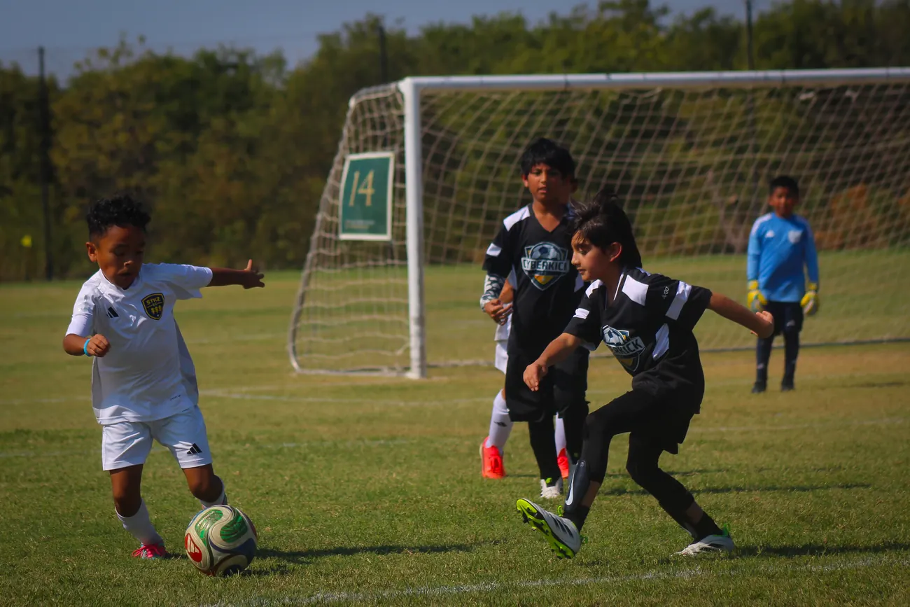 Youth soccer players attacking during a competitive match